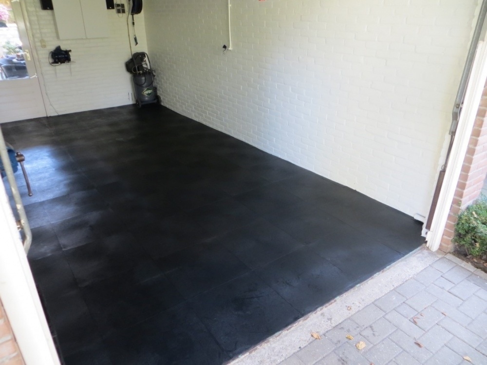 Zwarte pvc kliktegels gelegd in een garagevloer